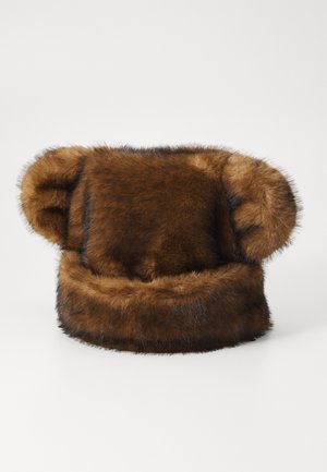 Brun faux fur hatt med runde ører, med en myk, fluffy tekstur og en tykk kant. Designet er voluminøst og rundt.