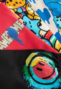 Fyra färgglada T-shirt-paneler: röd med texten "AWESOME", svart med en smiley-grafik, blå med serietidningskaraktärer och vit med färgplumpar.