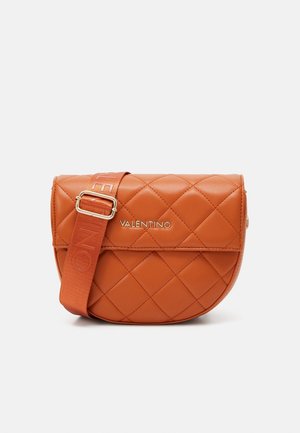 Sac en cuir orange matelassé avec une finition brillante, mettant en avant un logo doré et une bandoulière réglable à motifs.