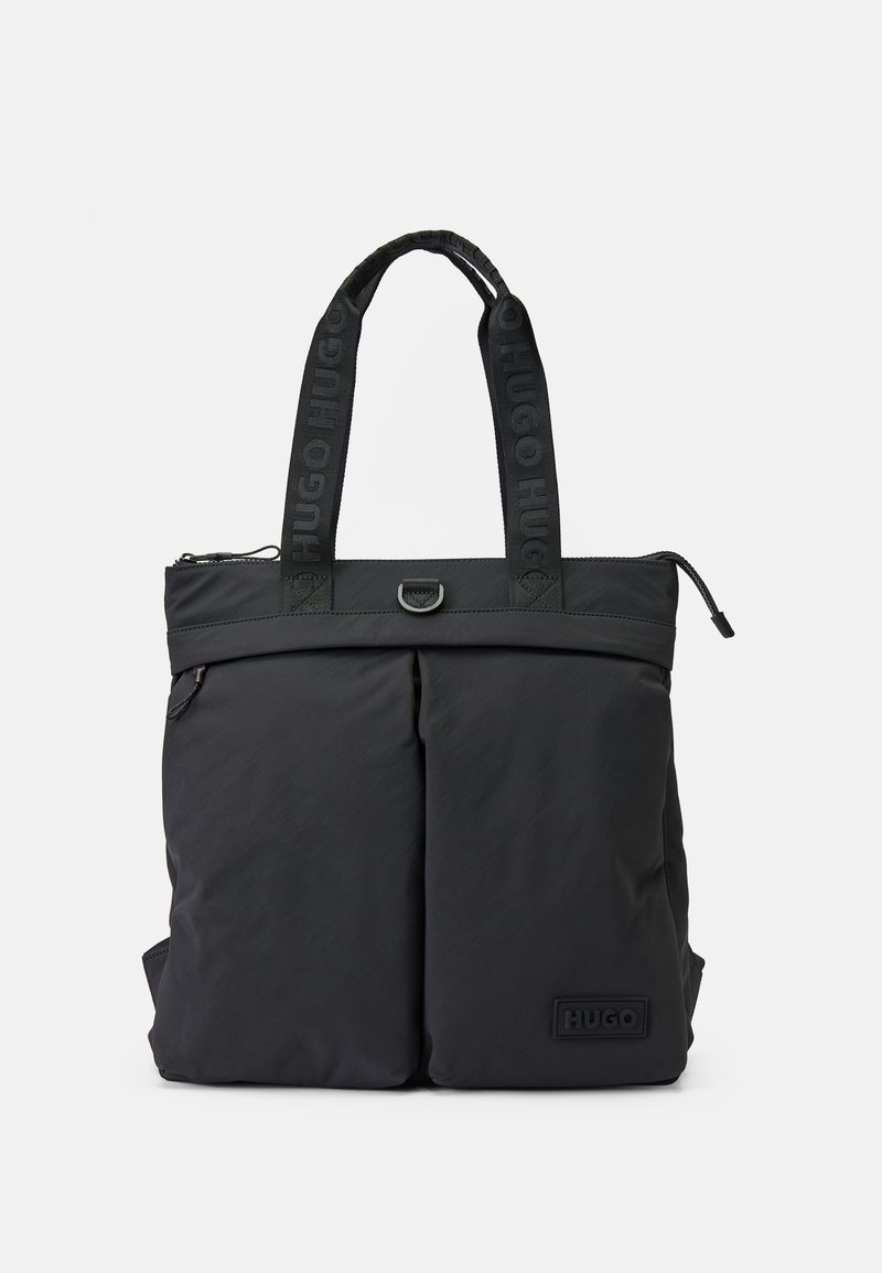 Sac fourre-tout noir Hugo avec poches avant doubles, poignées en tissu marquées, fermeture éclair et patch logo embossé dans le coin avant.
