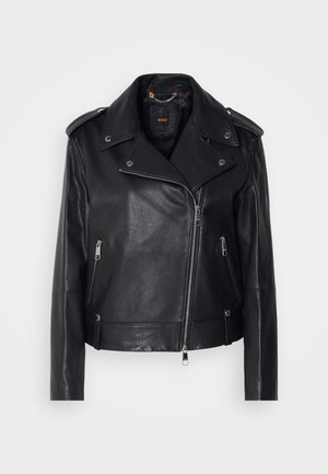Chaqueta de cuero negra de moto con un acabado texturizado, cremallera asimétrica, cuello con solapa y detalles en metal plateado. Presenta dos bolsillos laterales.