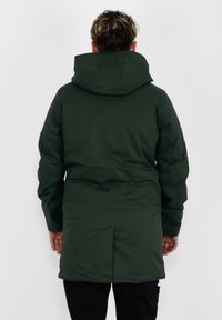Ciemnozielona, ocieplana kurtka z kapturem, o prostym kroju, z długimi rękawami i detalami szwów. Miękka w dotyku, widok od tyłu.