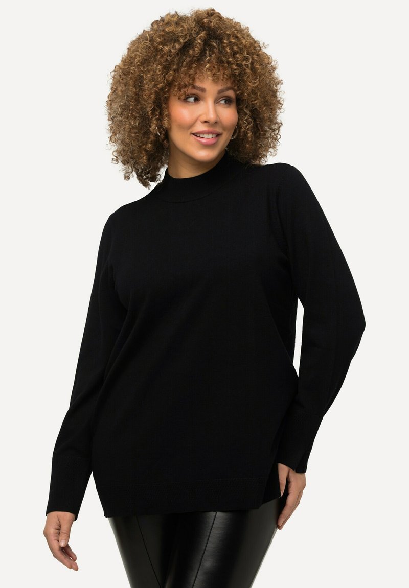 Maglione nero a maglia con scollo alto, maniche lunghe e vestibilità ampia. Presenta dettagli a coste sui polsini e l'orlo. Texture morbida.