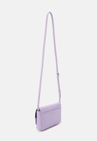 Liliowa torebka crossbody wykonana z gładkiego materiału syntetycznego, prostokątnego kształtu, z regulowanym paskiem i magnesowym zapięciem na klapę.