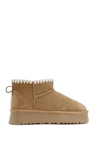 Tan suède enkelboots met een ronde neus, gegolfde kraagdetails en een textuur rubberen zool. Voorzien van een trekband aan de achterkant voor gemakkelijk aan- en uittrekken.