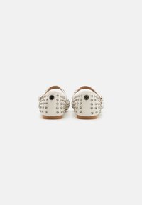 Scarpe in pelle bianca con design chiodato e decorazioni argentate. Tacco stondato con suola piatta e dettaglio della fascia regolabile.