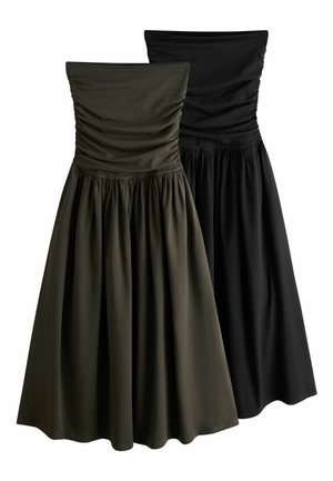 Dve šaty bez ramienok so zúženým vrškom s nariasenými zdobenými panelmi a s plnými nariasenými sukňami, jedna tmavozelená a jedna čierna, zobrazené na bielom pozadí.