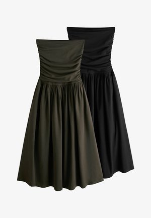 Kaksi olkaimetonta ryppyistä bodysmekkoa, joissa on kerätyt täysimittaiset hameet, yksi tummanvihreä ja yksi musta, esillä valkoisella taustalla.