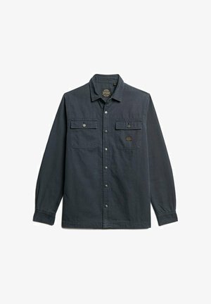Donker marineblauw shirt met lange mouwen en een button-down kraag, twee borstzakken met kleppen en drukknoopsluitingen. Zacht materiaal met een gestructureerde afwerking.