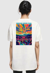  Weißes Baumwoll-T-Shirt mit einem bunten Grafikdruck auf der Rückseite, der eine Konzertszene mit lebhaften Strahlen und Bergen darstellt.