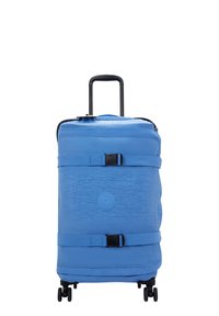 Rolling suitcase in textured light blue fabric, featuring a retractable handle, black wheels, and an adjustable strap across the front.