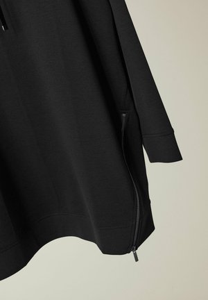 Czarna bluza z gładką fakturą, z zamkiem błyskawicznym w bocznej kieszeni i luźnym krojem. Długie rękawy i zaokrąglony dół.