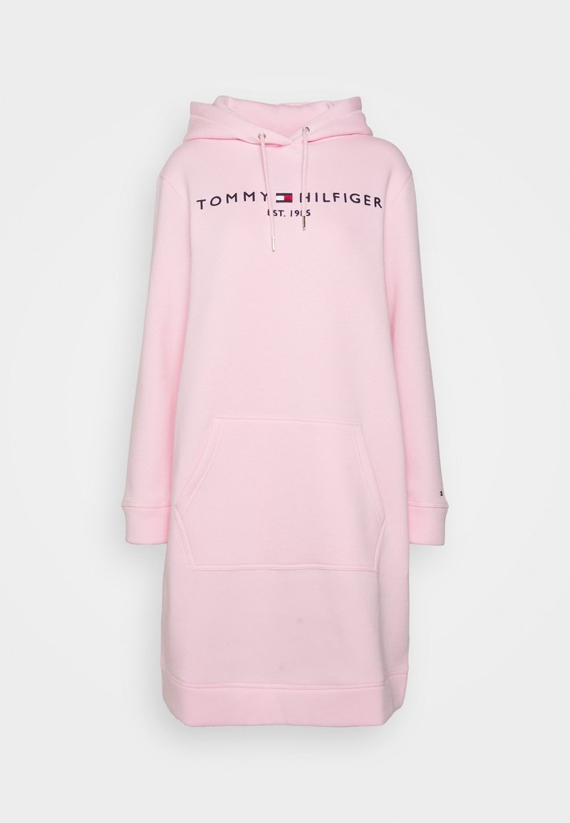 Robe sweat à capuche rose avec une poche avant, logo "TOMMY HILFIGER EST. 1985" en navy, et cordons avec embouts métalliques. Texture de tissu douce.
