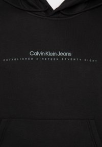 Czarna bluza z kapturem wykonana z gładkiego materiału, z przednią kieszenią i minimalistycznym designem z napisem "Calvin Klein Jeans" oraz "Established Nineteen Seventy Eight".