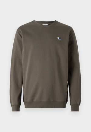 Šedý crewneck sveter vyrobený z bavlny, s malou výšivkou modrej a bielej vtáčika na ľavej strane hrude a ribbovanými manžetami.