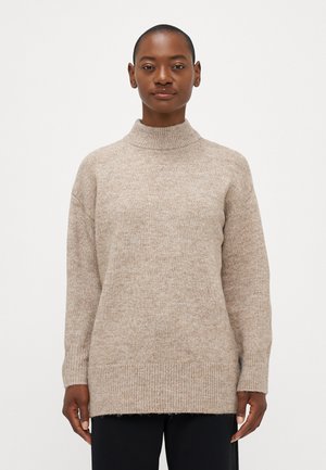 Beige knitted sweater with a high collar, loose fit, ribbed cuffs, and hem. The fabric appears soft with a textured surface.
