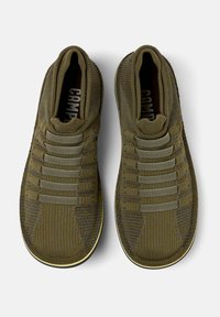 Green knit sneakers with elastic bands across the top, rounded toes, and a textured finish. The sole is lightly contrasting.