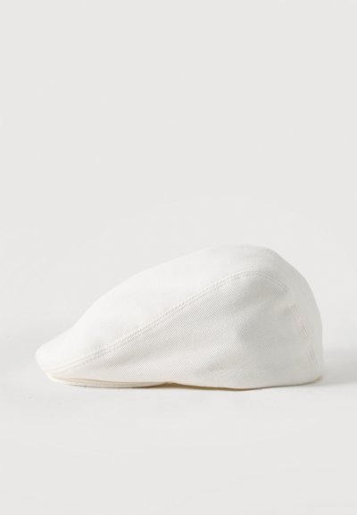 Λευκό επίπεδο καπέλο με κυρτή γείσο, κατασκευασμένο από υφή υφάσματος, αποτυπωμένο σε απλό φωτεινό φόντο.