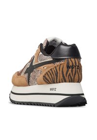 Sneaker con una toma beige e marrone in suede, dettagli in rete, accenti neri e un design a strisce di tigre testurizzate sul tallone. Suola spessa bianca.