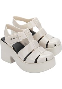 Sandali platform bianchi realizzati in materiale lucido, con punta chiusa e ritagli, e cinturini regolabili per una vestibilità sicura.