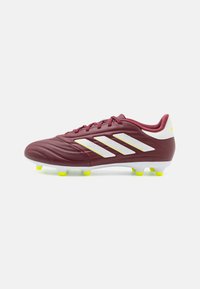Scarpino da calcio bordeaux con upper sintetico testurizzato, design a tre strisce bianche, tacchetti gialli e colletto imbottito. Adatto per superfici in erba.