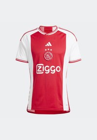 Czerwono-biała koszulka piłkarska Ajax z logo Adidas, trzema gwiazdkami nad herbem Ajaxu oraz logo sponsora Ziggo na przodzie.