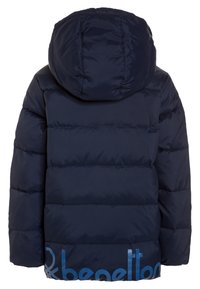 Mörkblå vadderad jacka med huva, quiltad design och delvis ljusblå "benetton"-logotyp längst ner på baksidan.