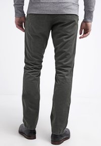 Tmavě zelené chinos ze 100% bavlněného kepru. Slim střih s jemnou texturou, přímo střižené nohavice a klasické zadní kapsy.