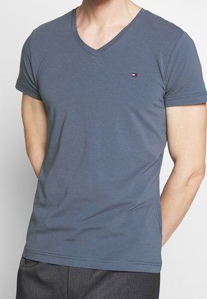 T-shirt med V-udskæring og korte ærmer i skifergrå bomuld med en lille logoaccents. Glat tekstur og tætsiddende pasform. Enkel og moderne stil.