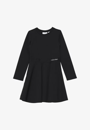 Abito nero a maniche lunghe in tessuto morbido, con corpetto aderente, gonna svasata e piccolo logo bianco "Calvin Klein" in vita.