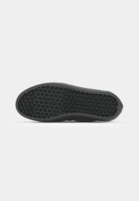 Svart sneaker såle med teksturert gummigrep som har et geometrisk mønster av diamanter og heksagoner, flat design, og avrundede kanter.