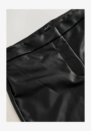 Black faux leather pants with a smooth texture, featuring a flat waistband, a front pocket, and a subtle brand label "NEXT" on the waistband.