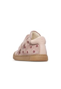 Sneakers en daim rose avec une petite broderie de fleur rouge, une semelle en caoutchouc beige et un talon rembourré pour le confort.