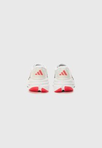Bijele atletske tenisice s sivim detaljima i ružičasto-crvenim gumama na potplatu. Sadrže Adidas logo u ružičastoj boji na peti i podstavljeni ovratnik.