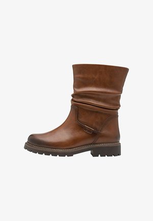 Bruine leren enkelboot met een versleten bovenkant, textuur op het oppervlak en een decoratieve band. De chunky zool met profiel biedt grip.