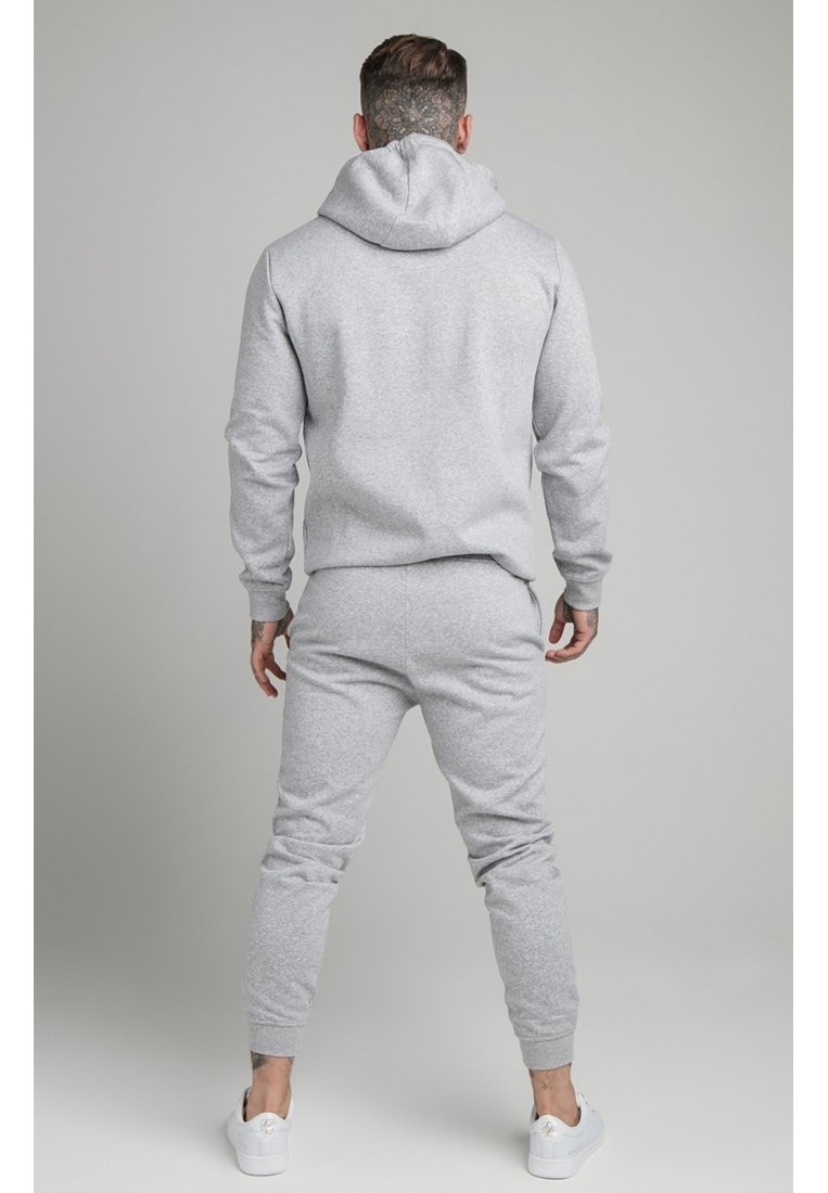 Conjunto de sudadera gris con capucha y pantalones de chándal, hecho de un tejido suave, que presenta un diseño ajustado y puños acanalados, con un bolsillo tipo canguro y capucha con cordón.