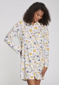Långärmad nattskjorta i lätt tyg med ett blommönster i gula, blå och gröna nyanser, med knappstängning framtill och ficka.