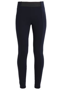 Marina leggings i stretchtyg med bred svarts midjeband och vertikal sömnad längs benen. Slät struktur över hela.