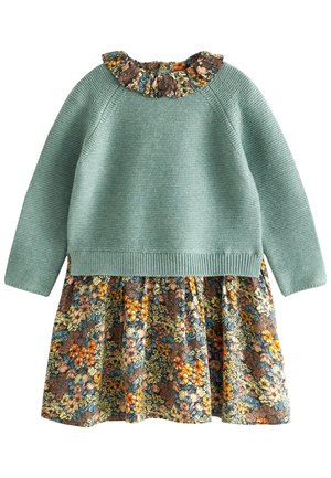 Haut en maille vert à manches longues avec jupe fleurie attachée et col volanté fleuri dans des tons orange, bleu, marron et crème.