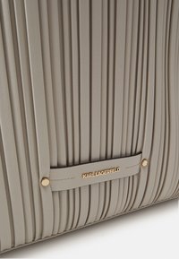 Geplooide grijze handtas gemaakt van gestructureerd materiaal. Bevat een logo accent in goudkleur en een schouderriem met een gouden knoopsluiting.