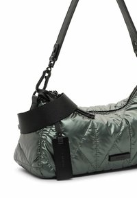 Gequilted, metallic groene schoudertas met een zwarte band en hardware. Opvallende dikke zwarte band aan de bovenkant en een logo-label eraan bevestigd.