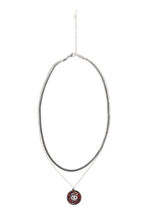 Zilveren gelaagde halsketting met twee kettingen, waarvan één met een ronde hanger met een wit oog en kleurrijke abstracte patronen.