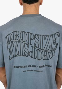 Gray cotton t-shirt featuring bold black text "DROPSIZE" and "DROPSIZE CLUB / EST. 2020" on the back, with a relaxed fit and crewneck design.