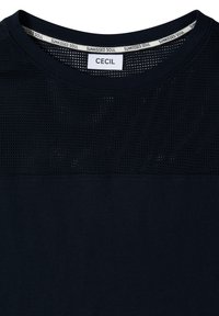 T-shirt noir col rond avec panneau supérieur en mesh, affichant l’étiquette « CECIL » et la bande intérieure du col avec le motif texte « SUNKISSED SOUL ».