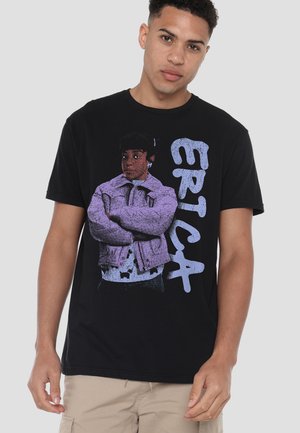 Black cotton t-shirt featuring a graphic print of a figure in a purple jacket and the word "ERICA" in light blue, with short sleeves.