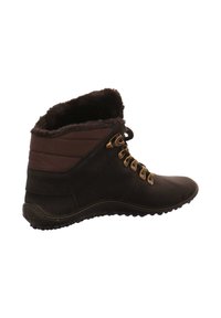 Schwarze Knöchelstiefel mit einem weichen, braunen Fellfutter, goldenen Ösen und einer strukturierten Gummisohle. Besitzt einen gepolsterten Knöchel für zusätzlichen Komfort.