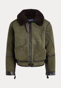 Grüne Wildlederjacke mit dunkelbraunem Lammfellkragen, Frontreißverschluss, großen Taschen, Lederbesatz und Reißverschluss an den Bündchen.