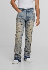 Wyblakłe dżinsy z teksturowaną, pikowaną powierzchnią i szerokimi nogawkami. Zawierają klasyczny pięciopocketowy krój oraz postrzępione końce.