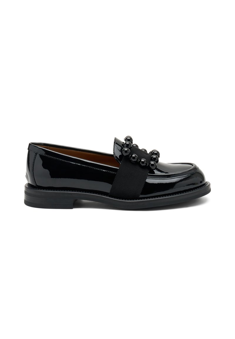 Mocassino in vernice nera con punta rotonda, cinturino elastico e perline decorative sul davanti. Suola piatta in gomma con tacco basso.