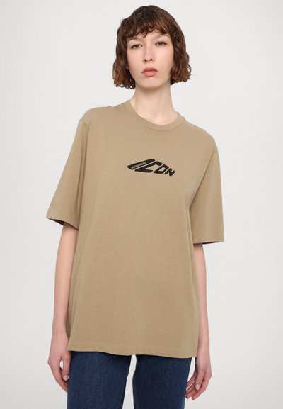 Khaki oversized T-shirt van katoen, met een zwart bedrukt logo op de voorkant, korte mouwen en een ronde hals.